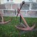 Two old and rusty ship anchors in a garden setting